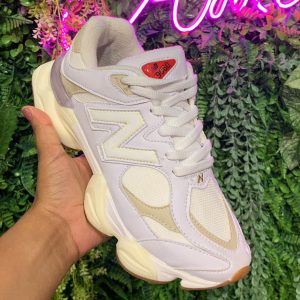 Tênis New Balance 9060 branco com detalhes em cinza e nude, solado caramelo, feito com tecido, camurça e couro ecológico.
